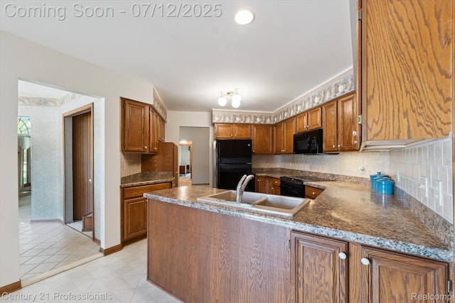 17012 Coral Ln, Macomb, MI 48042 - kitchen featuring black appliances, a peninsula, decorative backsplash, brown cabinets, and dark countertops