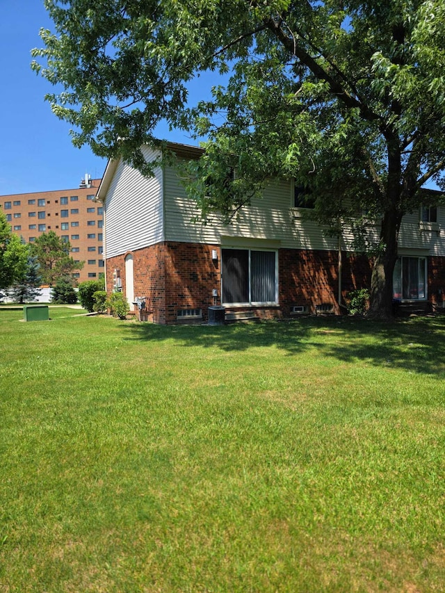 44497 Savery Dr, Canton, MI 48187 - rear view of property featuring brick siding and a yard