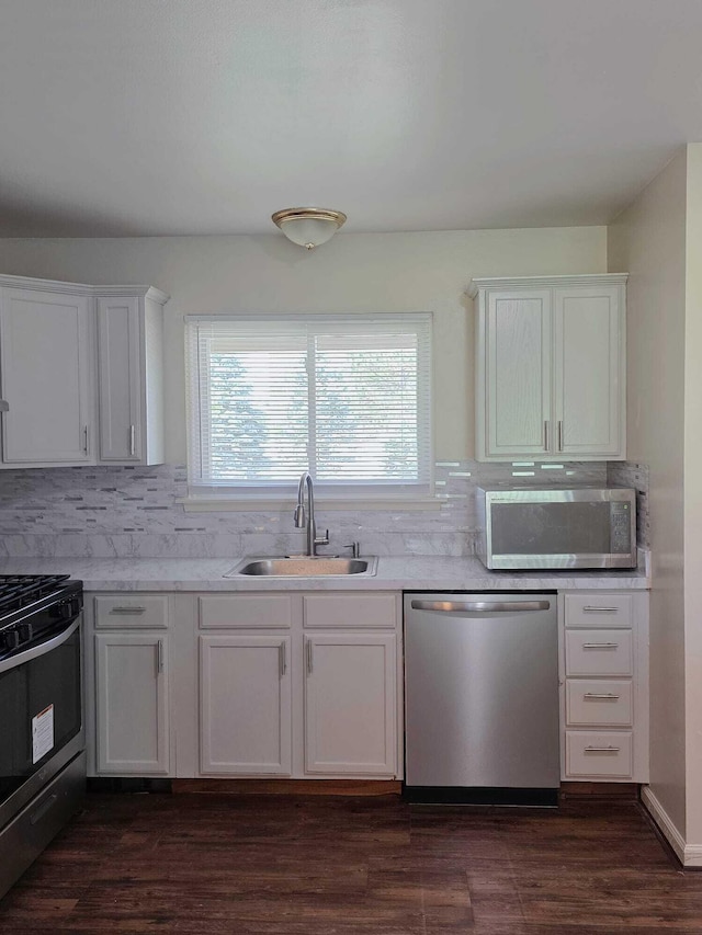 44497 Savery Dr, Canton, MI 48187 - kitchen featuring appliances with stainless steel finishes, tasteful backsplash, light countertops, white cabinetry, and dark wood-type flooring
