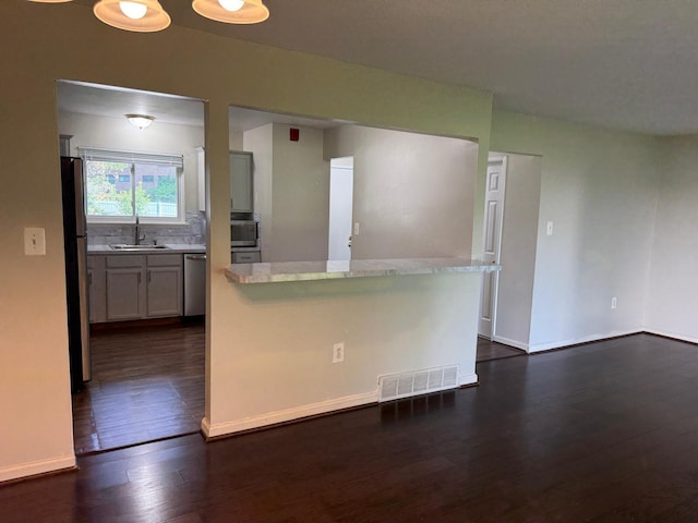 44497 Savery Dr, Canton, MI 48187 - kitchen with appliances with stainless steel finishes, dark wood-style flooring, a kitchen island, tasteful backsplash, and gray cabinetry