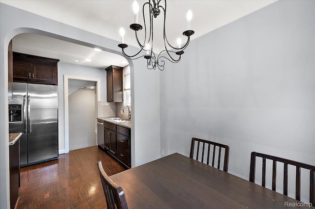 1450 Hampton Rd, Grosse Pointe Woods, MI 48236 - dining space with arched walkways, dark wood-style floors, and a chandelier