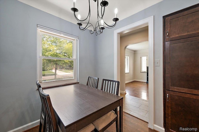 1450 Hampton Rd, Grosse Pointe Woods, MI 48236 - dining space with arched walkways, a chandelier, and dark wood-style flooring