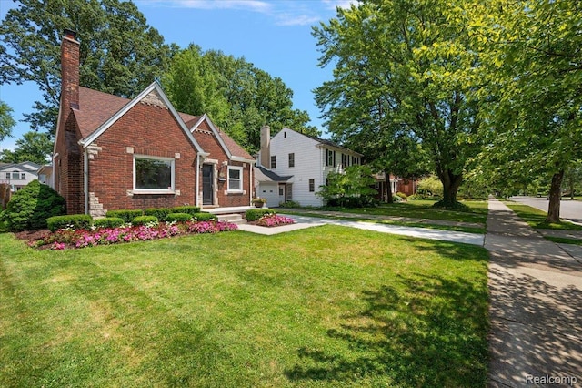 1450 Hampton Rd, Grosse Pointe Woods, MI 48236 - view of front facade with a chimney, brick siding, and a front lawn
