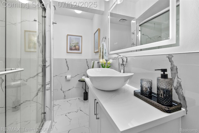 23167 Cromwell St, Canton, MI 48128 - bathroom featuring marble finish flooring, vanity, a marble finish shower, tile walls, and a wainscoted wall