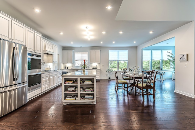 2448 Meadow Hills Dr, Ann Arbor, MI 48108 - kitchen with stainless steel appliances, light countertops, white cabinetry, a kitchen island, and decorative backsplash