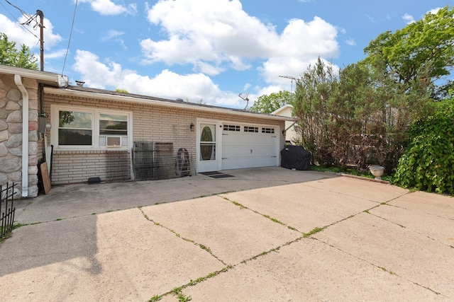 753 Vaniman Island Dr, Brooklyn, MI 49230 - view of side of property featuring driveway, a garage, brick siding, and stone siding