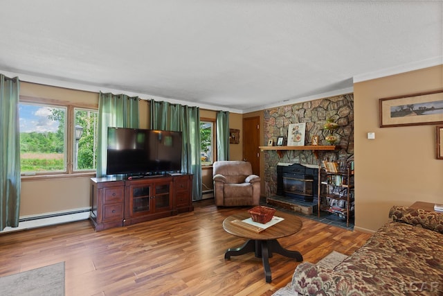 753 Vaniman Island Dr, Brooklyn, MI 49230 - living area with wood finished floors, baseboard heating, a stone fireplace, and ornamental molding