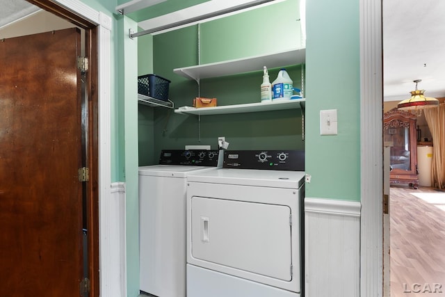 753 Vaniman Island Dr, Brooklyn, MI 49230 - laundry area featuring washer and clothes dryer, a wainscoted wall, and wood finished floors