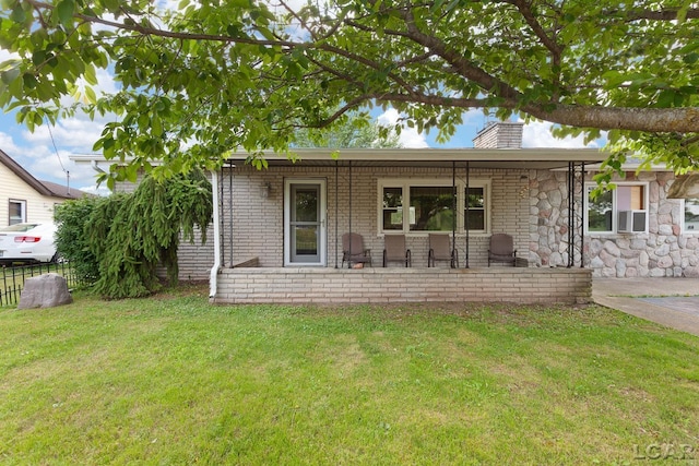 753 Vaniman Island Dr, Brooklyn, MI 49230 - rear view of house featuring a chimney, covered porch, brick siding, and cooling unit