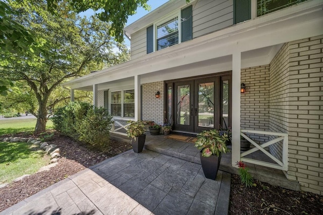4550 Comanche Dr, Okemos, MI 48864 - property entrance featuring brick siding, french doors, and covered porch