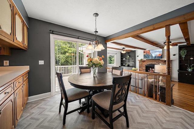 4550 Comanche Dr, Okemos, MI 48864 - dining area with beamed ceiling, a brick fireplace, and a ceiling fan