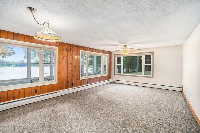 193 S Emerson Dr, Branch, MI 49402 - carpeted spare room with a ceiling fan, a textured ceiling, a baseboard heating unit, a water view, and wood walls