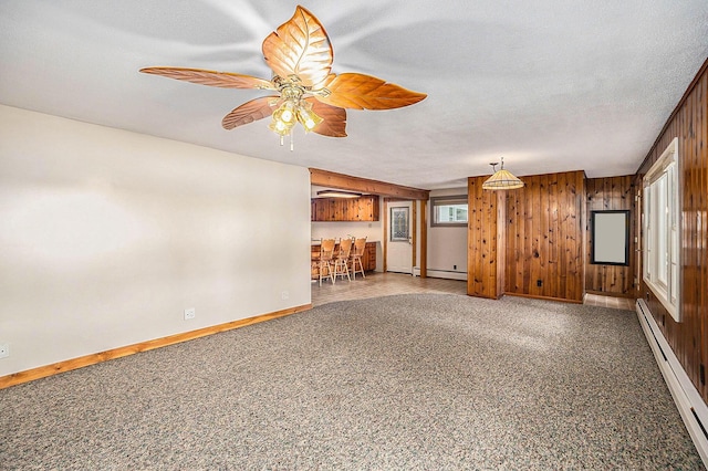 193 S Emerson Dr, Branch, MI 49402 - unfurnished living room with baseboard heating, a ceiling fan, and wooden walls