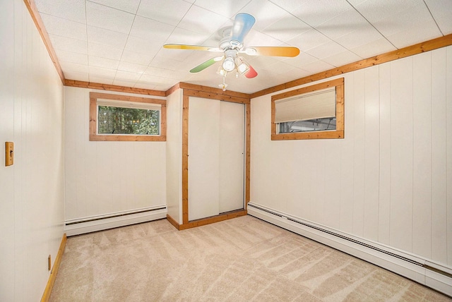 193 S Emerson Dr, Branch, MI 49402 - spare room with baseboard heating, carpet floors, wood walls, and ceiling fan