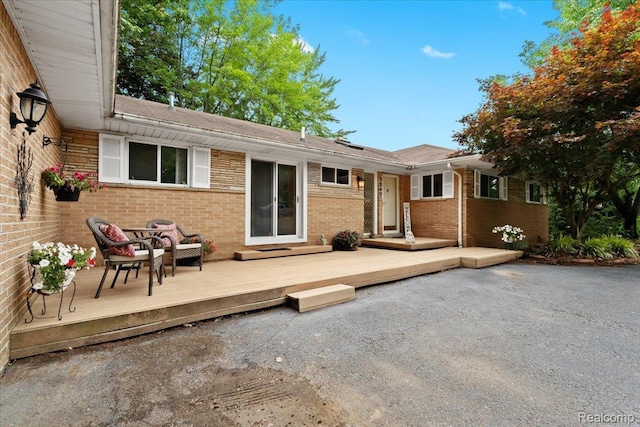 1540 Milford Hills Dr, Milford, MI 48381 - back of house with brick siding, a wooden deck, a shingled roof, and a patio area