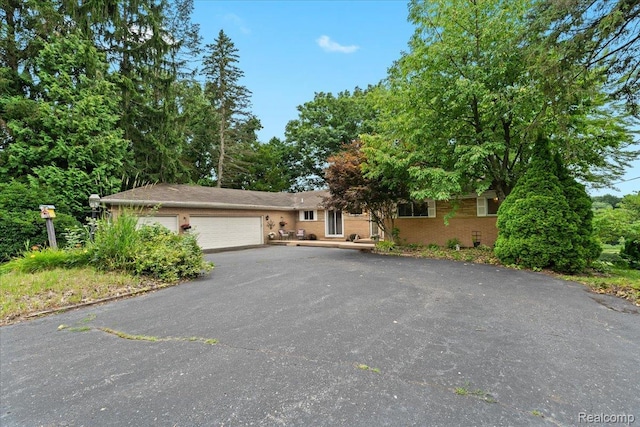 1540 Milford Hills Dr, Milford, MI 48381 - view of front of home featuring an attached garage, driveway, and brick siding