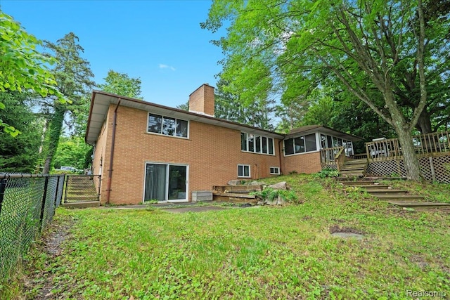 1540 Milford Hills Dr, Milford, MI 48381 - back of property with a chimney, a deck, brick siding, and a sunroom