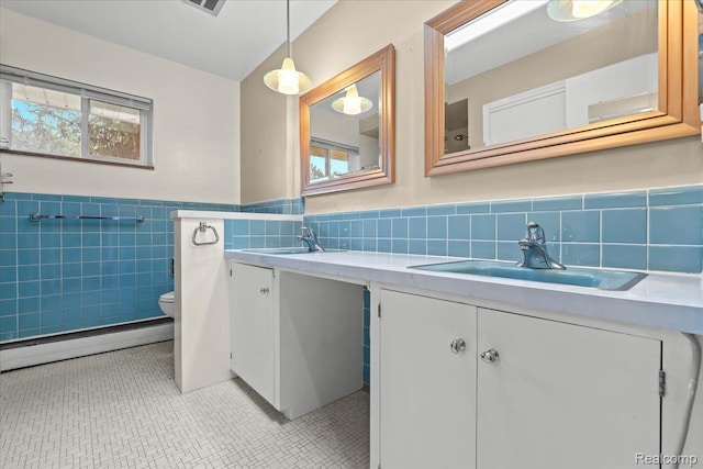 1540 Milford Hills Dr, Milford, MI 48381 - full bathroom with double vanity, a baseboard radiator, tile walls, a wainscoted wall, and tile patterned flooring
