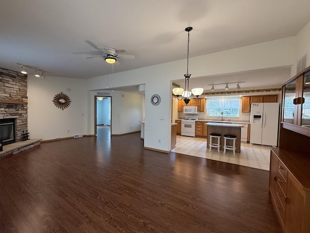 7826 Sunset Shores Dr Unit 43, Canadian Lakes, MI 49346 - living area with rail lighting, light wood finished floors, ceiling fan, and a fireplace