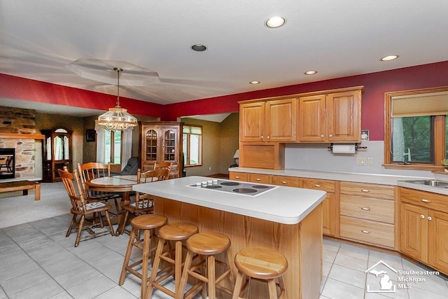 5237 Emerson Dr, Ottawa Lake, MI 49267 - kitchen featuring electric cooktop, light countertops, a breakfast bar area, a center island, and hanging light fixtures