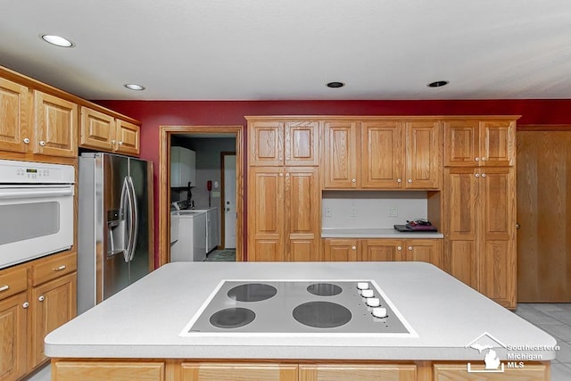 5237 Emerson Dr, Ottawa Lake, MI 49267 - kitchen featuring oven, stainless steel fridge with ice dispenser, electric stovetop, washer and clothes dryer, and a kitchen island
