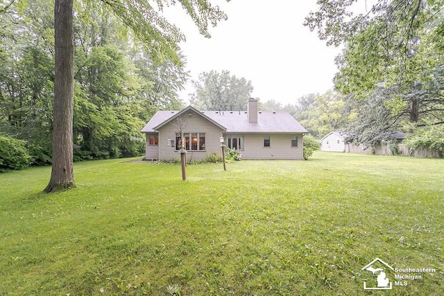 5237 Emerson Dr, Ottawa Lake, MI 49267 - rear view of house featuring a chimney and a lawn