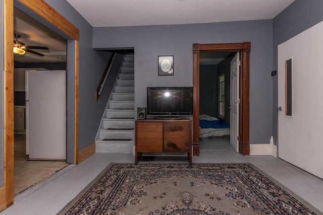 1228 Wells Pl, Kalamazoo, MI 49001 - living room with stairs, a ceiling fan, and concrete floors
