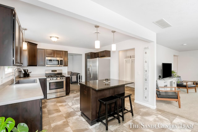 568 N River Hills Dr, Newaygo, MI 49337 - kitchen featuring appliances with stainless steel finishes, dark brown cabinets, a breakfast bar area, a kitchen island, and hanging light fixtures