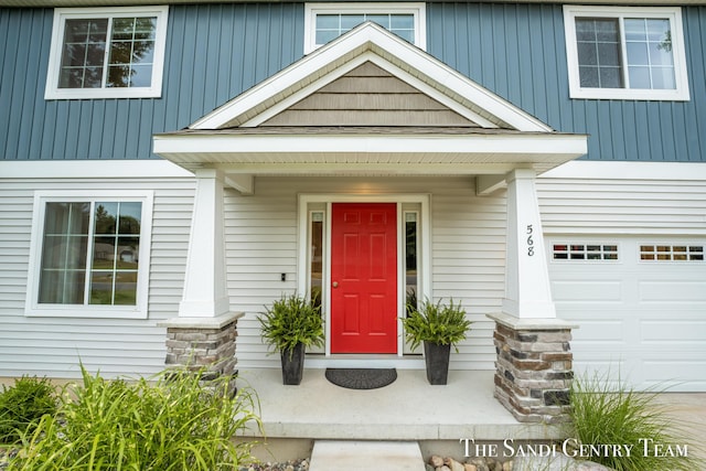 568 N River Hills Dr, Newaygo, MI 49337 - view of exterior entry with an attached garage and covered porch