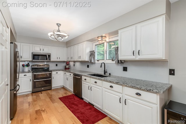 2661 Nottingham, Waterford, MI 48329 - kitchen with appliances with stainless steel finishes, light wood-style floors, decorative backsplash, and a chandelier