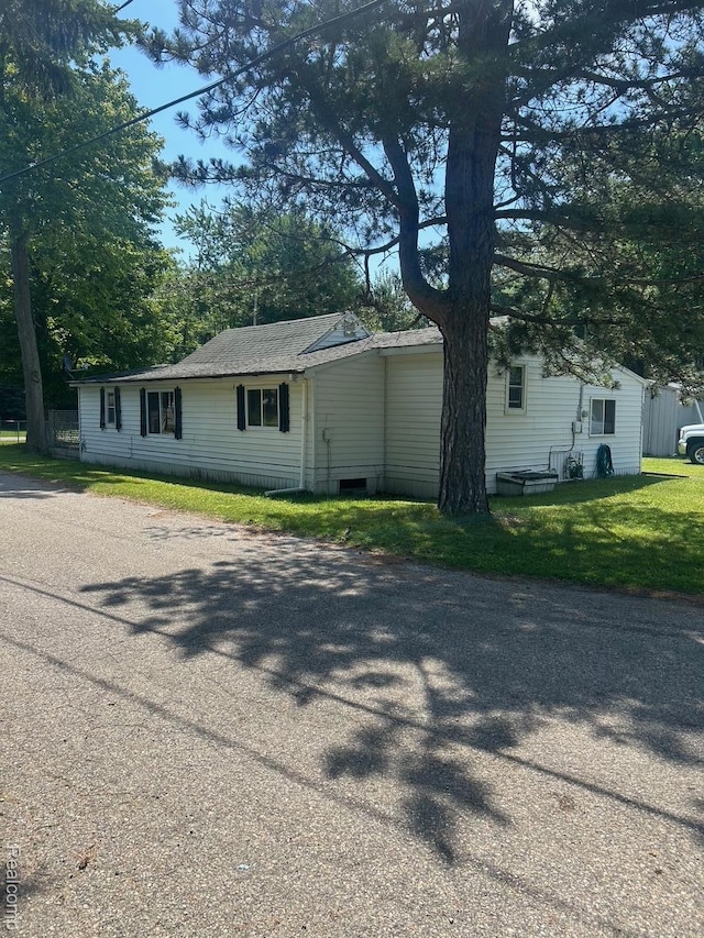 1023 Lakewood Dr, East Tawas, MI 48730 - view of front facade featuring a front lawn