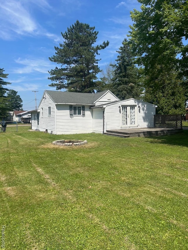 1023 Lakewood Dr, East Tawas, MI 48730 - view of front of house with a wooden deck and a front yard