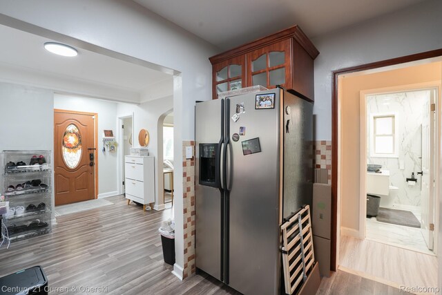 5720 Argyle St, Dearborn, MI 48126 - kitchen with stainless steel fridge, arched walkways, wood finished floors, and glass insert cabinets