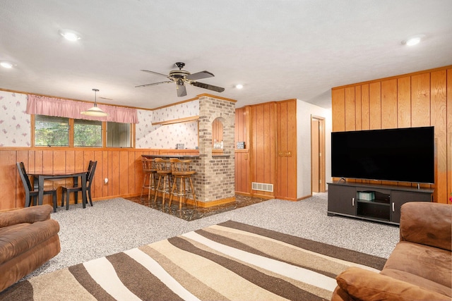 6580 Sunflower Dr SW, Byron Center, MI 49315 - carpeted living room featuring a dry bar, wallpapered walls, a ceiling fan, wooden walls, and recessed lighting