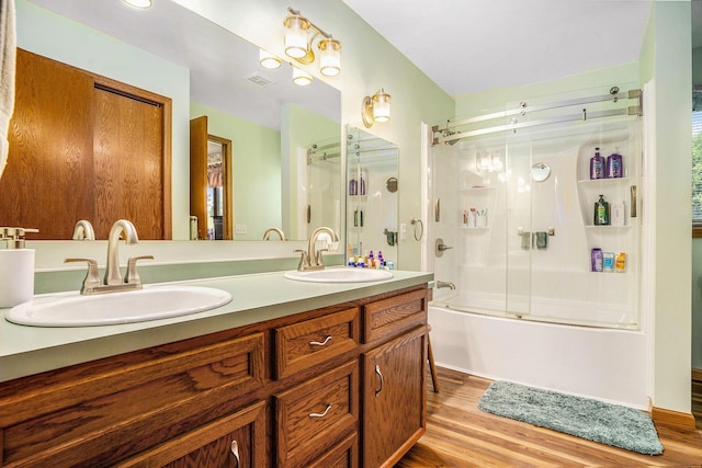 6580 Sunflower Dr SW, Byron Center, MI 49315 - full bathroom featuring double vanity, wood finished floors, and enclosed tub / shower combo