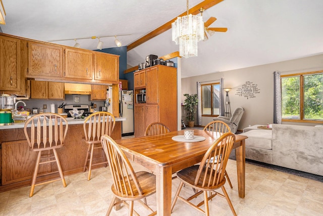 6580 Sunflower Dr SW, Byron Center, MI 49315 - dining area featuring vaulted ceiling, track lighting, ceiling fan, and a chandelier