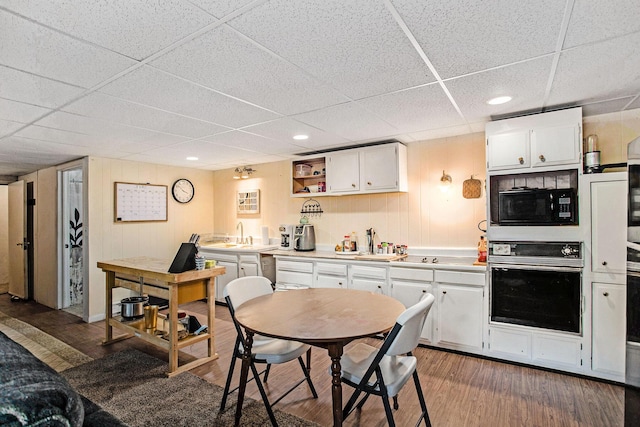 12972 S M 43 Hwy, Delton, MI 49046 - kitchen with wall oven, black microwave, a drop ceiling, white cabinets, and wood finished floors