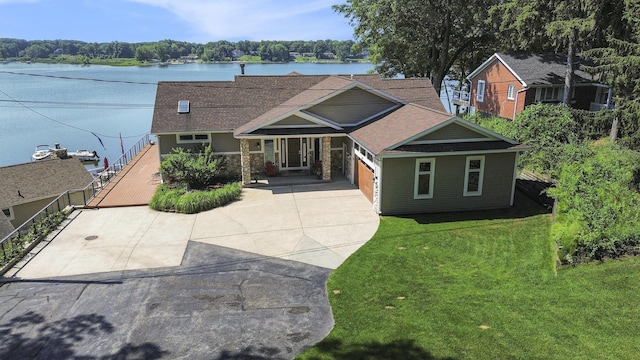 481 Seminole Rd, Norton Shores, MI 49444 - craftsman-style house featuring driveway, a front yard, roof with shingles, a garage, and a water view