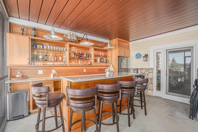 481 Seminole Rd, Norton Shores, MI 49444 - indoor wet bar featuring concrete floors, wooden ceiling, wood walls, and decorative light fixtures