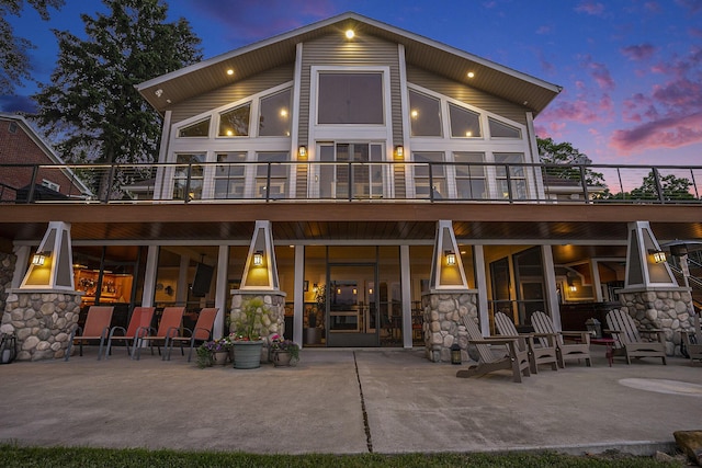 481 Seminole Rd, Norton Shores, MI 49444 - rear view of property featuring a patio, stone siding, and a balcony