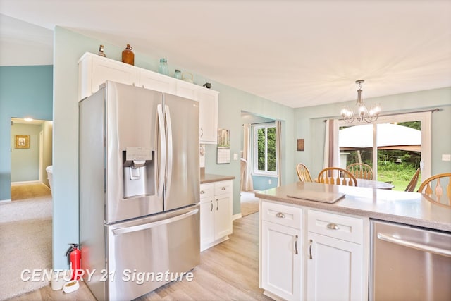 11315 Grand Oaks Dr, Clio, MI 48420 - kitchen featuring stainless steel appliances, white cabinetry, and a chandelier