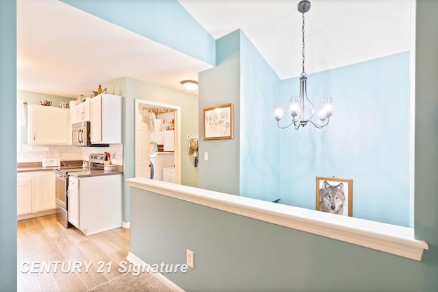 11315 Grand Oaks Dr, Clio, MI 48420 - kitchen featuring stainless steel appliances, white cabinets, a chandelier, decorative backsplash, and washer / dryer