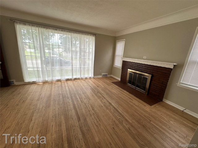 16684 Forest Ave, Harrison Township, MI 48021 - unfurnished living room with healthy amount of natural light, wood finished floors, a brick fireplace, and a textured ceiling