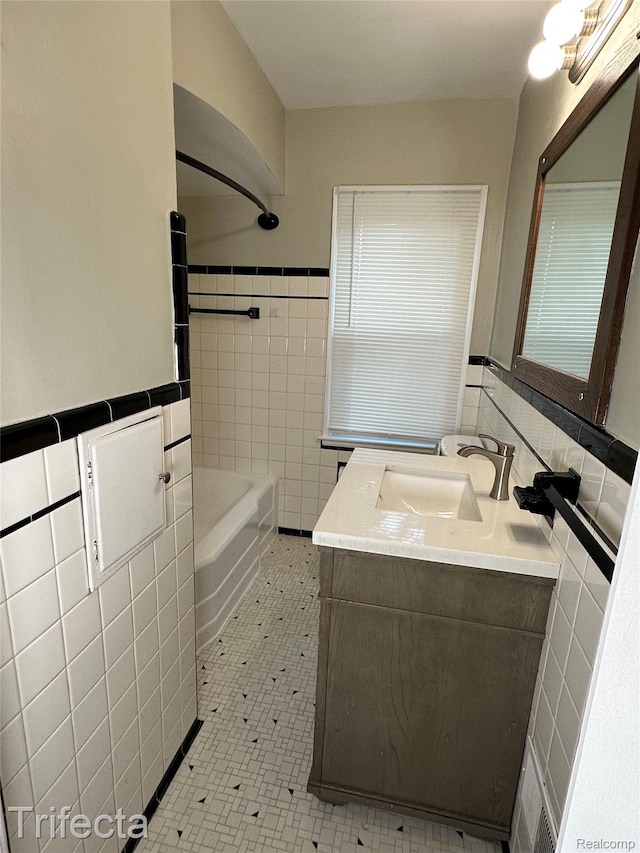 16684 Forest Ave, Harrison Township, MI 48021 - bathroom featuring tile walls, vanity, washtub / shower combination, and a wainscoted wall