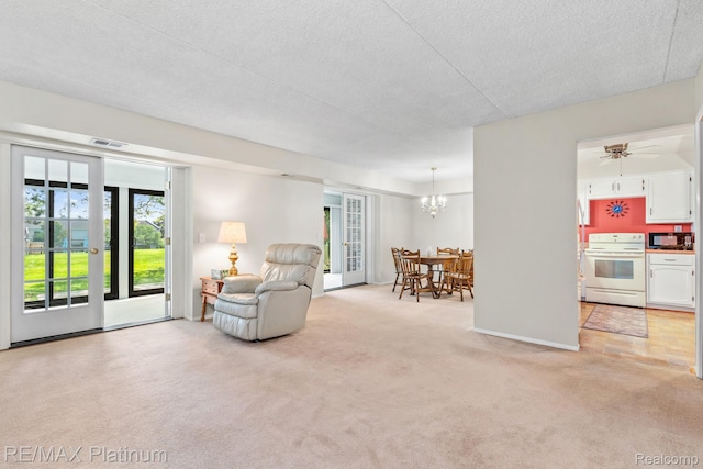 17979 University Park Dr, Livonia, MI 48152 - living area featuring light carpet, a textured ceiling, and a chandelier