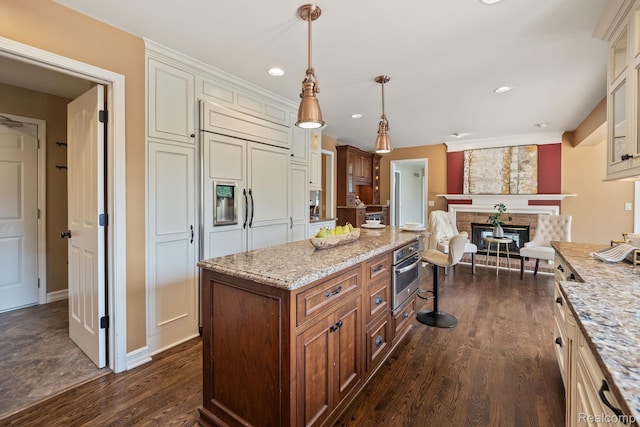 1257 Lake Shore Blvd, Lake Orion, MI 48362 - kitchen featuring dark wood finished floors, a kitchen breakfast bar, light stone counters, oven, and a brick fireplace
