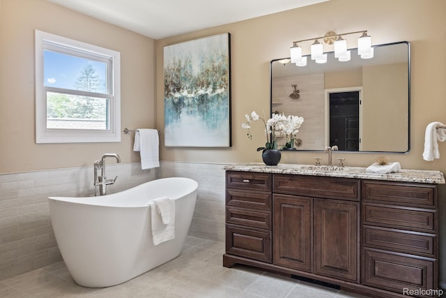 1257 Lake Shore Blvd, Lake Orion, MI 48362 - full bathroom featuring tile walls, tile patterned floors, vanity, a soaking tub, and a wainscoted wall
