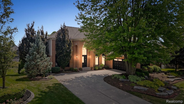 1257 Lake Shore Blvd, Lake Orion, MI 48362 - view of property hidden behind natural elements with driveway, an attached garage, and a front yard