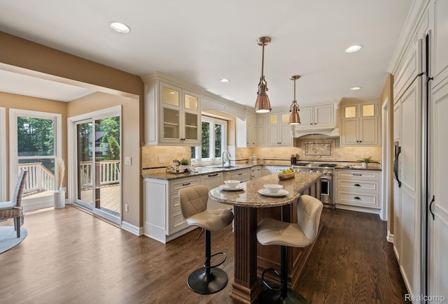 1257 Lake Shore Blvd, Lake Orion, MI 48362 - kitchen with stainless steel stove, a kitchen island, dark wood-style floors, light stone counters, and backsplash