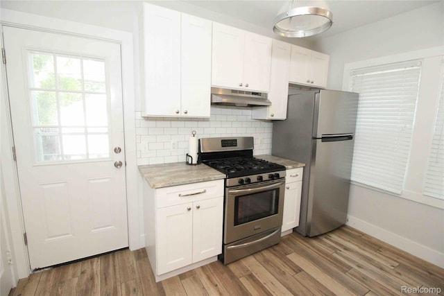 1324-1322 Wayburn St, Grosse Pointe, MI 48230 - kitchen with appliances with stainless steel finishes, under cabinet range hood, light wood-style floors, white cabinetry, and backsplash